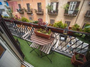 balkon ze stołem i ławką z roślinami w obiekcie Itiseasy Palermo 1 e 2 Private Apartments w mieście Palermo