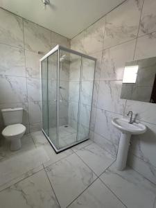a bathroom with a shower and a toilet and a sink at Pousada Recanto Da Fé in Aparecida