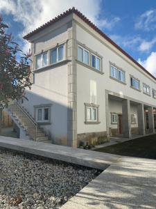 une grande maison blanche avec des escaliers en face de celle-ci dans l'établissement Casa da Moagem, à Vinhais