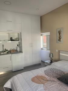 une chambre blanche avec un lit et une cuisine dans l'établissement Casa da Moagem, à Vinhais