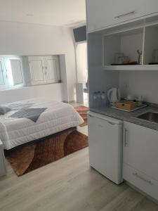 Una cocina blanca con una cama en una habitación en Casa da Moagem, en Vinhais