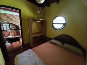 ein Schlafzimmer mit einem Bett, einem Fenster und einem Hund in der Unterkunft Eldorado Discépolo in Eldorado