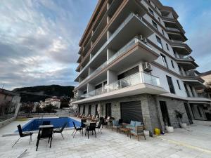a apartment building with a swimming pool and chairs at Elia Hotel Residence in Budva