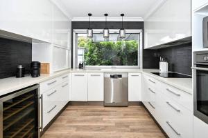 a white kitchen with white cabinets and a window at Golden Beach Family Relaxation in Golden Beach