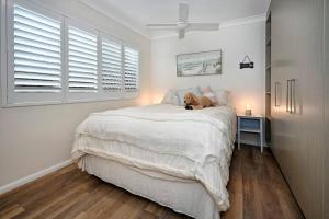 a teddy bear sitting on a bed in a bedroom at Golden Beach Family Relaxation in Golden Beach +17 photos