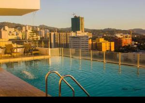a swimming pool on top of a building with a city at Condo units in Mabolo Garden Flats Cebu in Cebu City