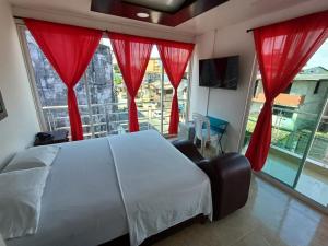 een slaapkamer met een groot bed en rode gordijnen bij HOTEL DULCES SUEÑOS in Buenaventura