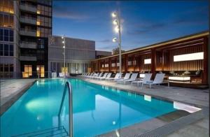 a large swimming pool with white chairs in a building at 300 Front Suites - Two Beds with Free Parking in Toronto
