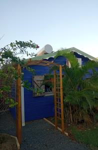 una casa azul con una escalera delante de ella en La Mare à Cuja, en Sainte-Rose