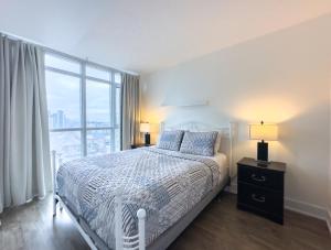 um quarto com uma cama e uma grande janela em 300 Front Suites - Two Beds with Free Parking em Toronto