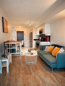 a living room with a blue couch and a kitchen at 300 Front Suites - Two Beds with Free Parking in Toronto