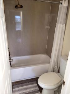 a bathroom with a white tub and a toilet at Cozynest2 in Boynton Beach +8 photos
