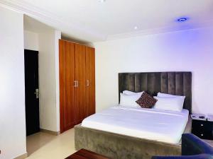 a bedroom with a large bed with a wooden headboard at Vintage Classic Suites in Lagos