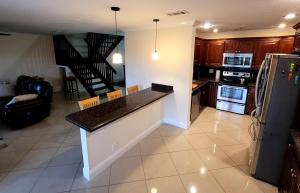 a kitchen with a counter and a living room at Cozynest2 in Boynton Beach