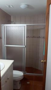 een badkamer met een douche, een toilet en een wastafel bij Departamento Dúplex Colonial in Quito