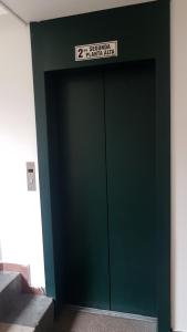 een groene deur in een gebouw met een bord erop bij Departamento Dúplex Colonial in Quito