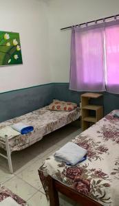 a room with two beds and a purple curtain at Hostel Brasil Recife in Recife