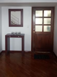 een kamer met een deur, een tafel en een spiegel bij Departamento Dúplex Colonial in Quito