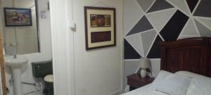 a bedroom with a bed and a sink and a mirror at Aracari Inn Mindo in Mindo