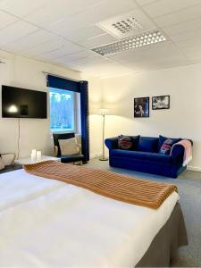 una camera con un grande letto e un divano blu di Route 154, 15 min till Ullared a Älvsered