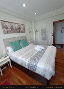 a bedroom with a large bed with green pillows at Habitación 1 con vistas in Bilbao