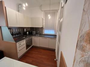 a kitchen with white cabinets and a stove top oven at Mimi’ House in Cantù