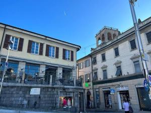 a building with a clock tower on a city street at Mimi’ House in Cantù