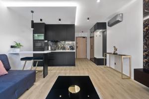 Apartament Park Partynice في فروتسواف: مطبخ وغرفة معيشة مع أريكة زرقاء
