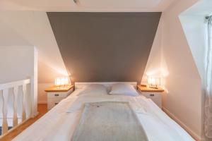 - une chambre avec un grand lit et deux lampes dans l'établissement Kastanienhof Hagebutte, à Wisch