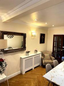 uma sala de estar com um espelho e uma cadeira em Casa Marina- 4 bedroom house with garden and balcony em Golders Green