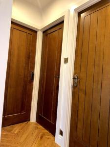 Duas portas de madeira num quarto com pisos de madeira em Casa Marina- 4 bedroom house with garden and balcony em Golders Green