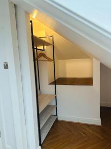 um quarto no sótão com uma escada numa casa em Casa Marina- 4 bedroom house with garden and balcony em Golders Green