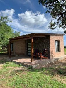 a small brick house with a patio and a table at Portezuelo de árboles in Panaholma