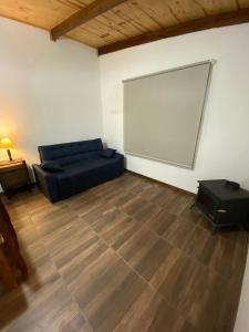 uma sala de estar com um sofá e um grande ecrã em Portezuelo de árboles em Panaholma