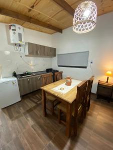 a kitchen with a wooden table and chairs and a table and a refrigerator at Portezuelo de árboles in Panaholma