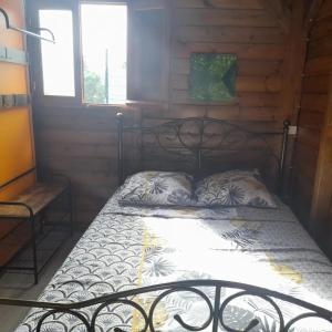 a bed in a wooden cabin with a metal headboard at Gite de Germaine in Sainte-Anne +10 photos