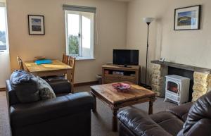 a living room with a couch and a table and a fireplace at The Linhay in Bridport