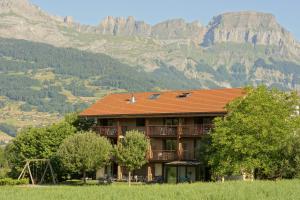 a building with a mountain in the background at Auberge de l'Orangerie - Sure Hotel Collection by Best Western in Sallanches