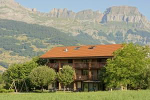a building with a mountain in the background at Best Western Plus Pays du Mont Blanc in Sallanches