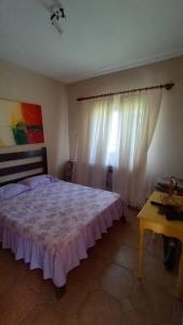 1 dormitorio con cama, mesa y ventana en Linda chácara no Itambé, en Ribeirão Preto