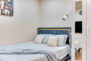 a bedroom with a bed with blue sheets and pillows at Adorable new studio with free parking and WiFi in Federal Way