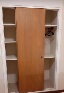 a closet with a wooden door and shelves at Apart Decorama in Dolores