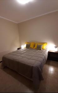 1 dormitorio con 1 cama grande con almohadas amarillas en Apart Decorama en 