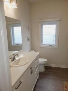 uma casa de banho branca com um lavatório e um WC em Adorable Cottage Port Stanley em Port Stanley
