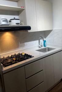 a kitchen with a stove top and a sink at Apartamento laureles Estadio Medellín 203 balcon in Medellín