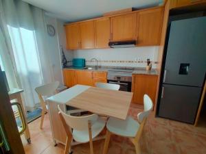 a kitchen with a table and chairs and a refrigerator at Casa ELENA i MARTA , Valdelinares in Valdelinares