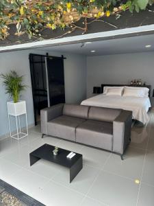 a bedroom with a bed and a couch and a table at Hotel Joy Cll 85 in Bogotá