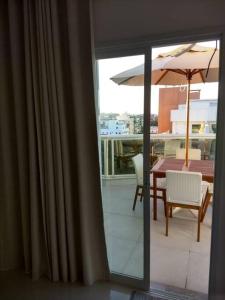 a view of a balcony with a table and umbrella at Apartamento Duplex (Cobertura) Praia do Forte in Cabo Frio