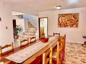 - une salle à manger avec une table et des chaises en bois dans l'établissement Spacious artsy home with fast WiFi, à Oaxaca
