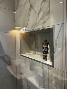 baño con espejo y una botella de crema de afeitar en The Old School House Retreat, en Tibberton